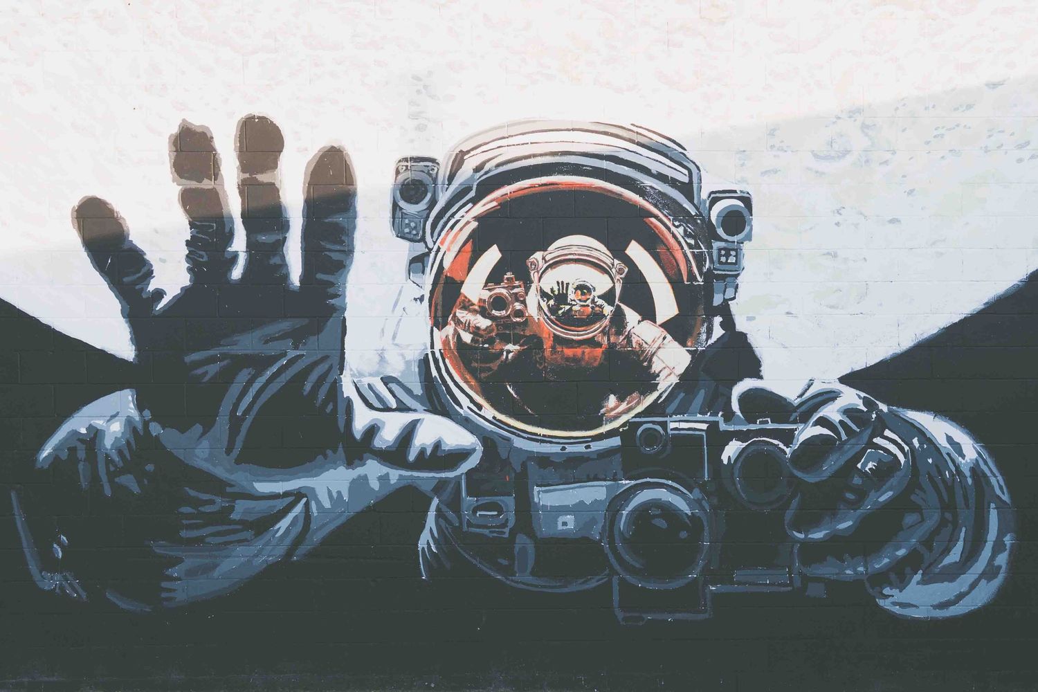 Silhouette of an astronaut floating in space with reflective helmet and suit details against dark background.