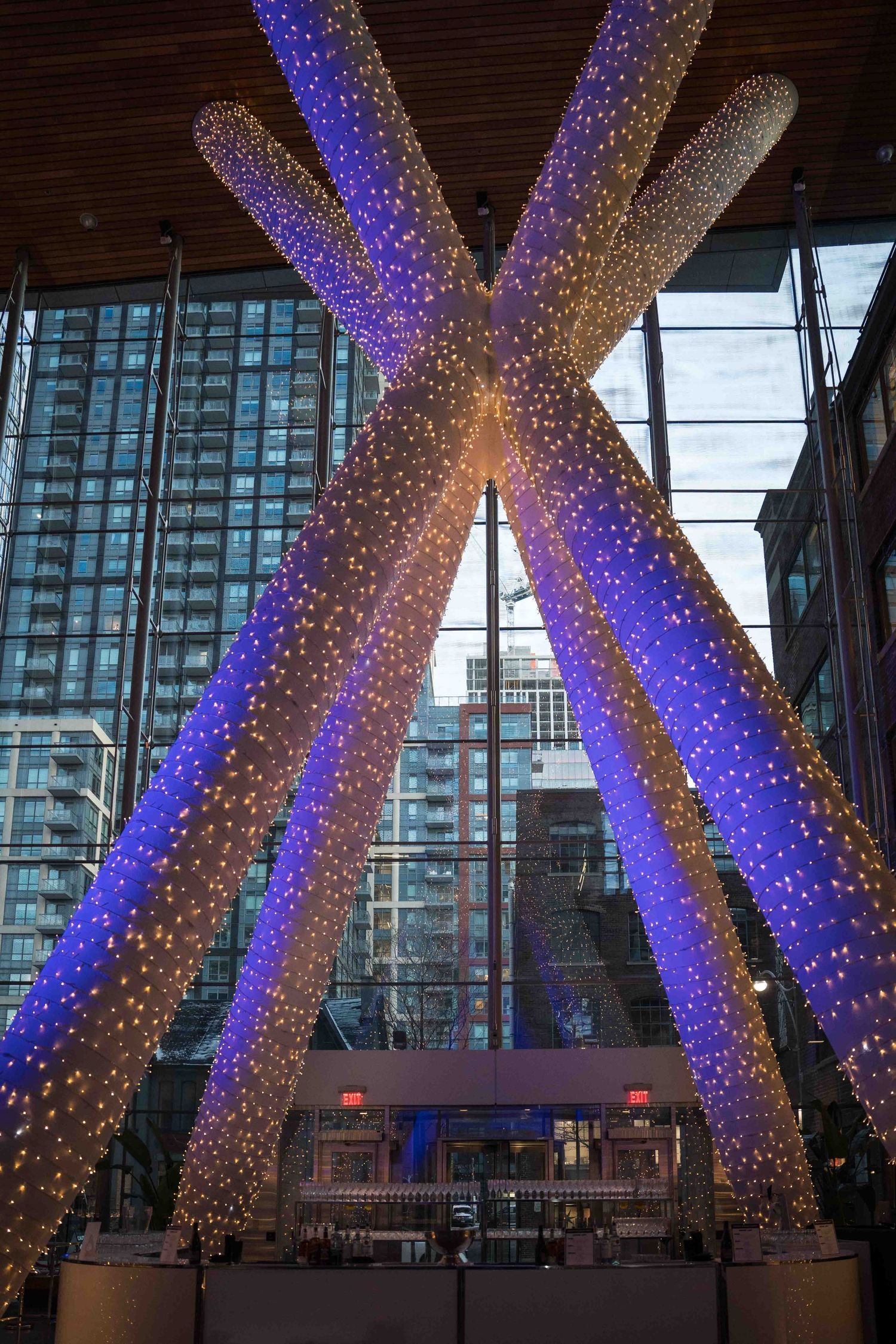 Modern architectural installation with illuminated cross-shaped structures glowing blue and gold.