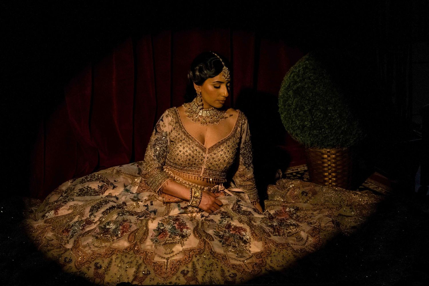 A collection of moody, dimly lit photos showing someone in traditional Indian bridal attire against dark backgrounds.