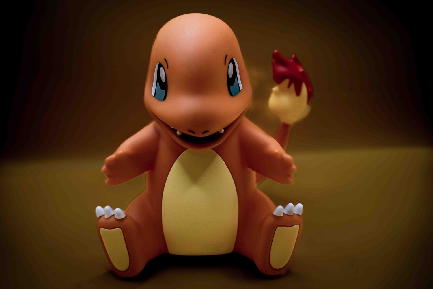 Orange Charmander Pokemon plush toy shown from multiple angles in dramatic lighting.