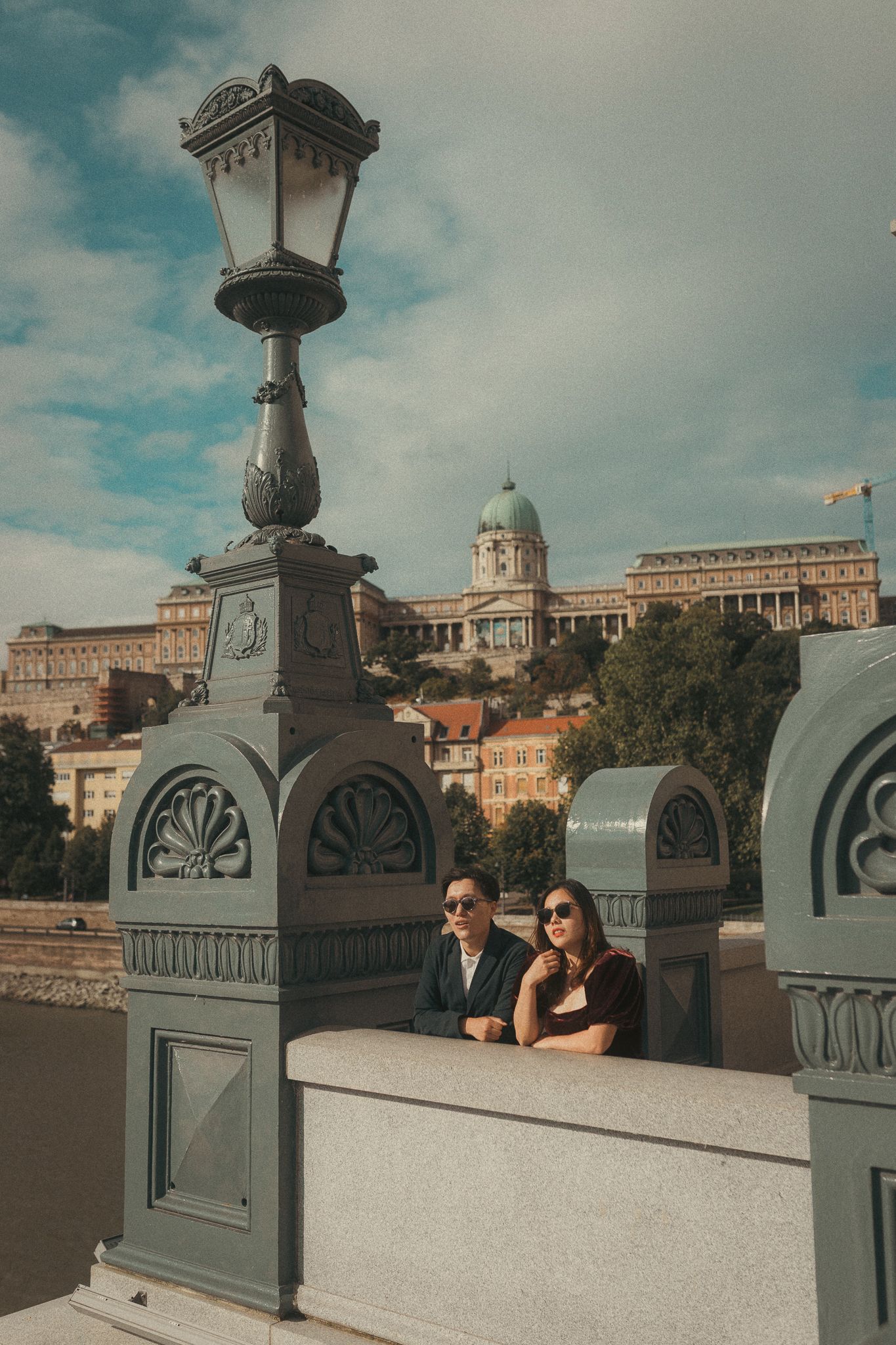 Couple at Chain Bridge in Budapest, with Buda Castle behind them.