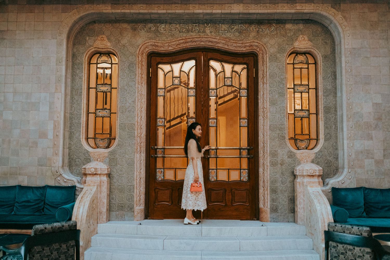 Elegant, young woman standing at the staircase doors of Four Seasons hotel in Budapest