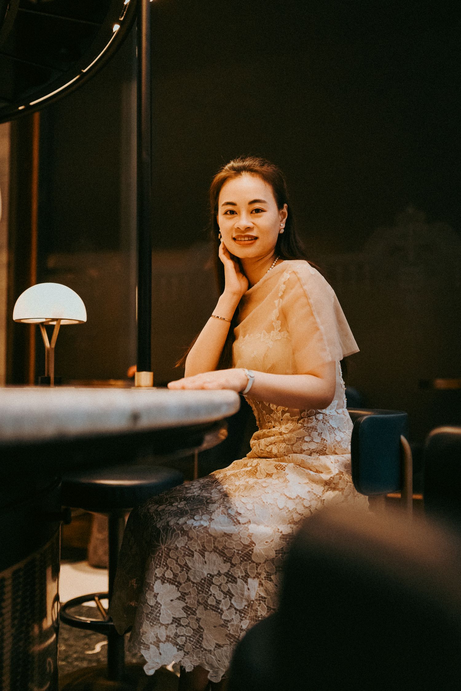 Young woman sitting at the bar of Four Seasons hotel in Budapest, posing for the camera during her professional photo shoot