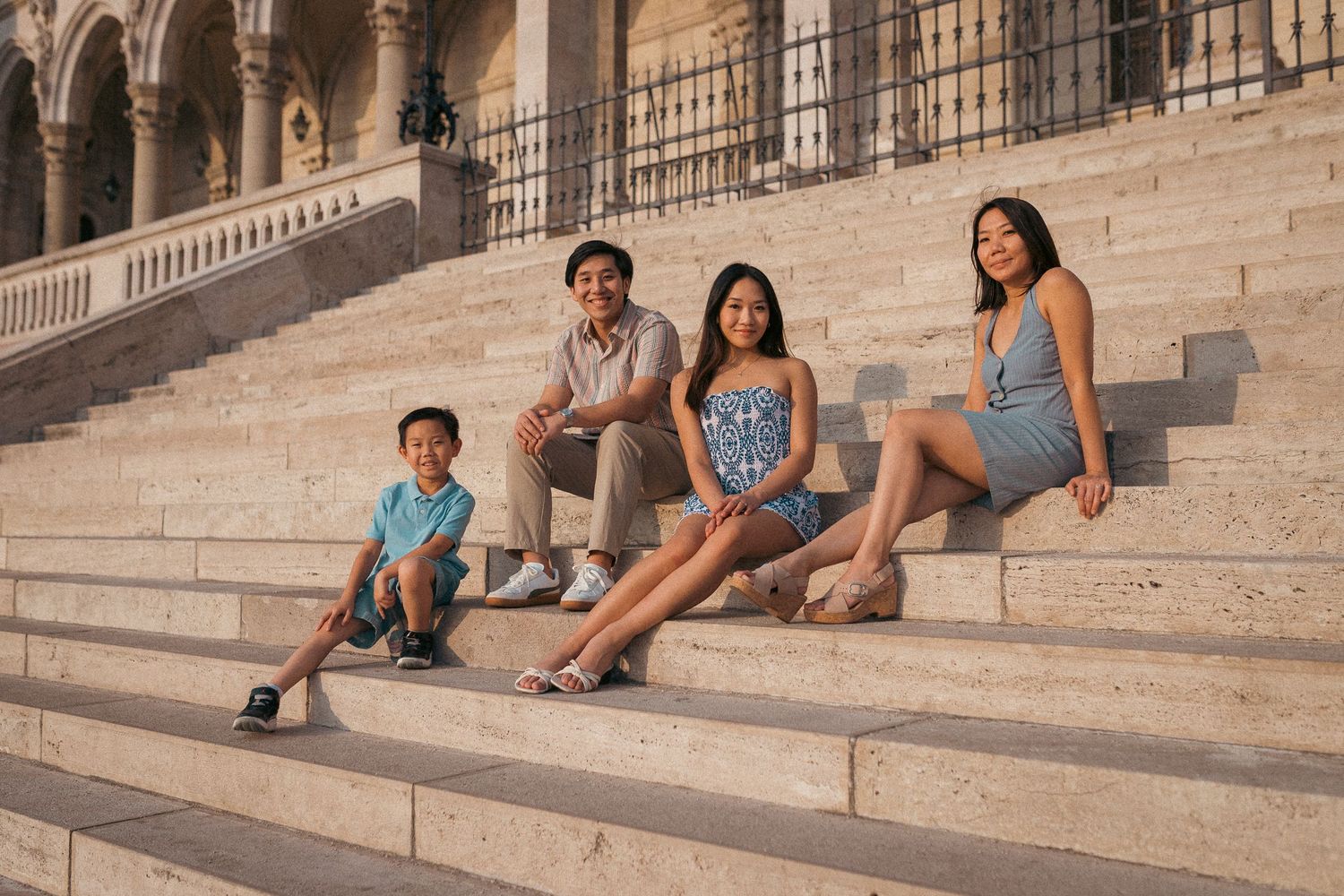 Mom and her three kids posing for the camera at the stairs of the Hungarian Palriament building
