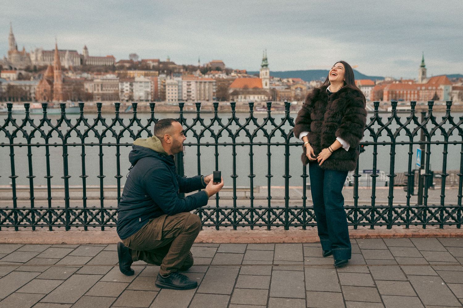 Surprise proposal near the Parliament building in Budapest, with the Castle Hill in the background