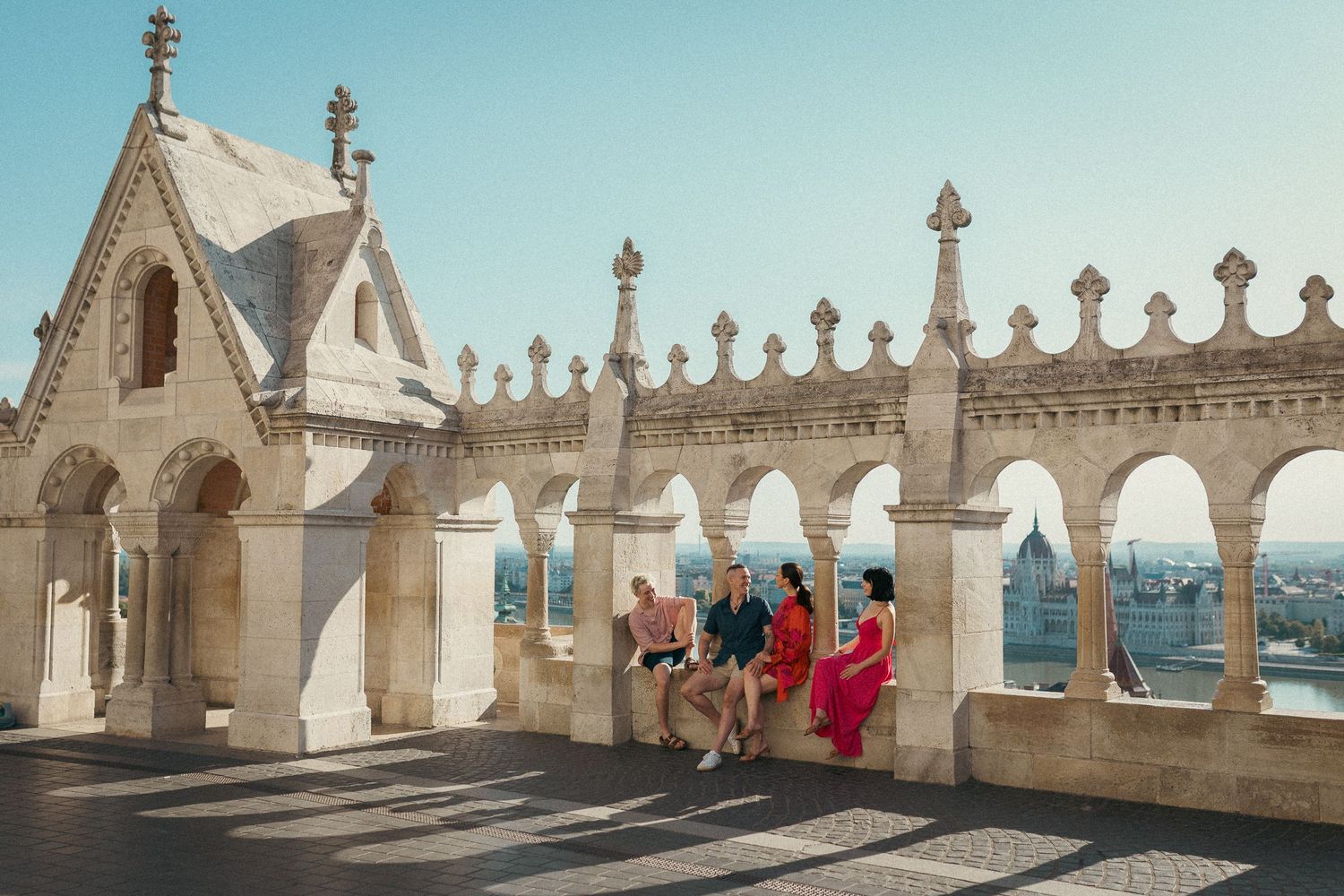Family of four sitting at the arches of Fisherman's Bastion during their summer family photo session.