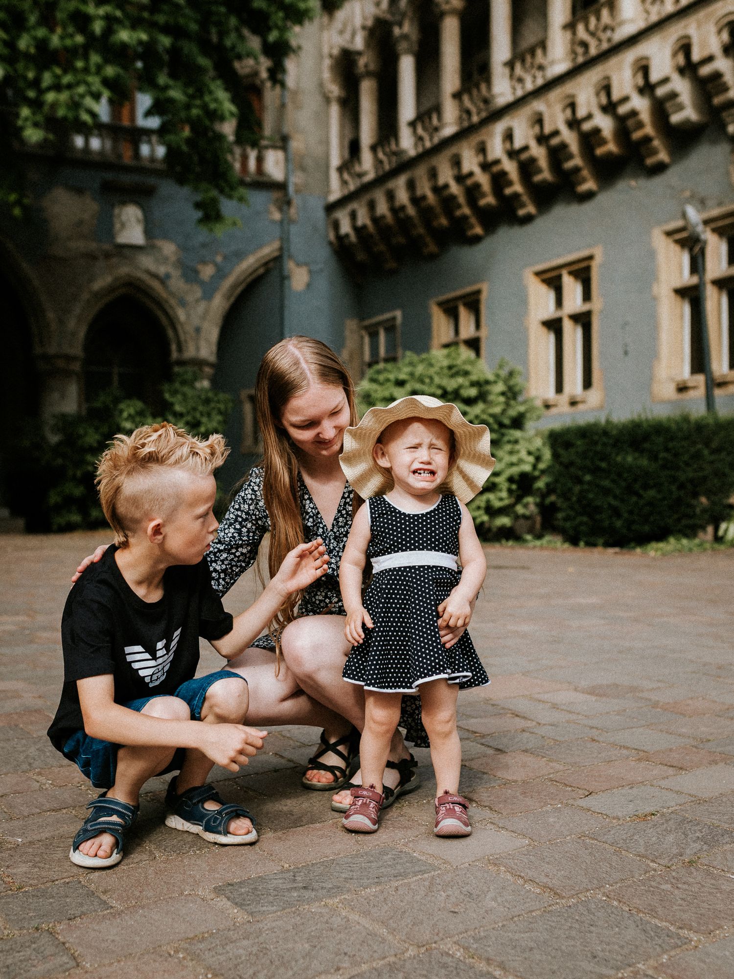 Three siblings during their family photo shoot at Vajdahunyad Castle in Budapest