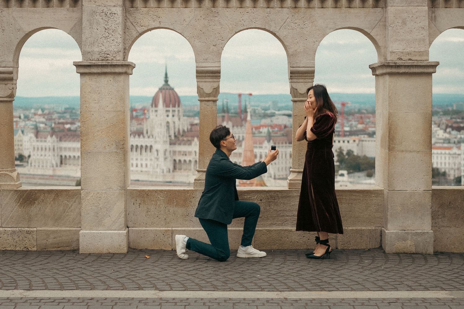 Candid portrait of Asian couple's surprise proposal at Fisherman's Bastion in Budapest