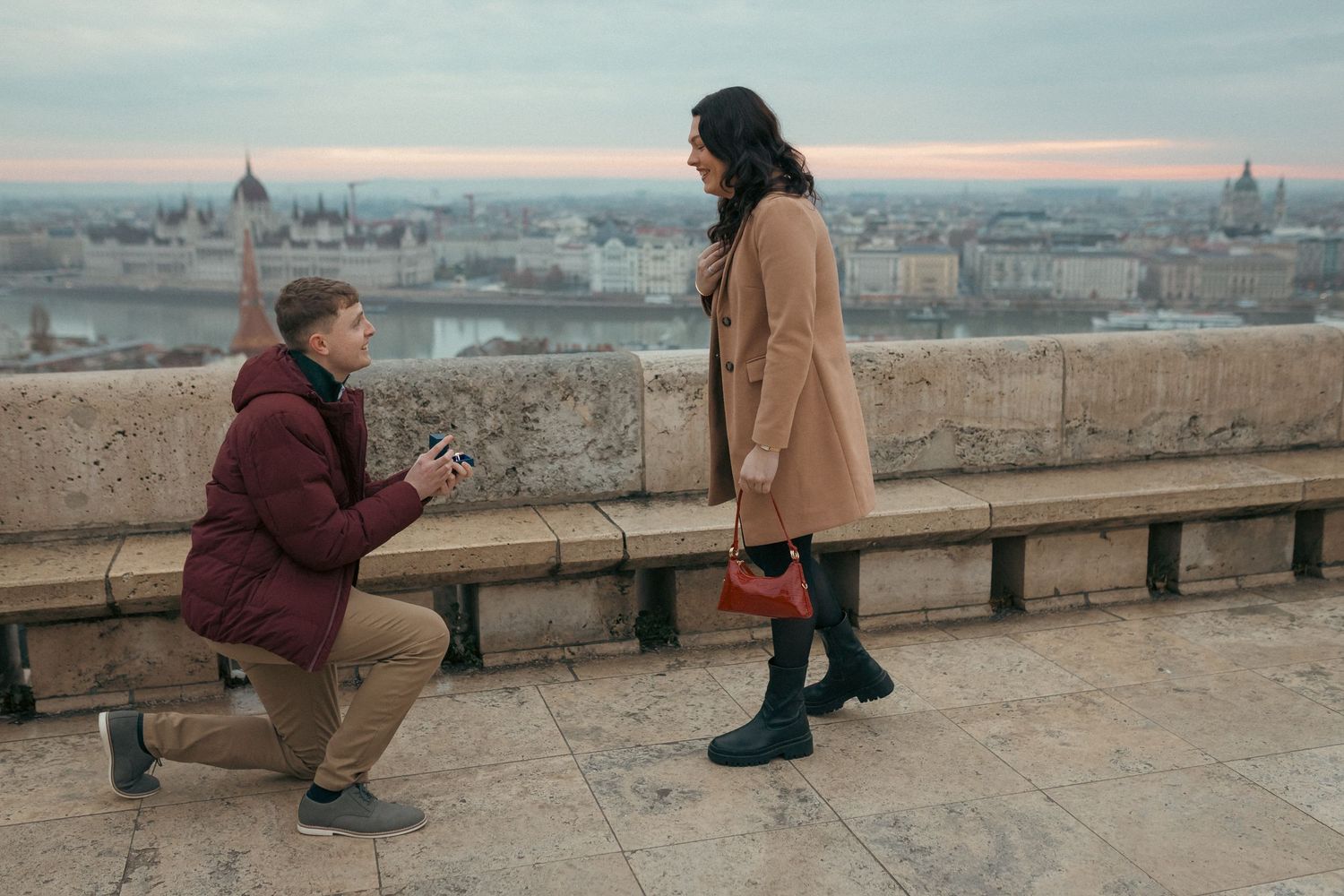 The moment of a surprise proposal during a professional photoshoot at sunrise at the terrace of Fisherman's Bastion in Budapest.