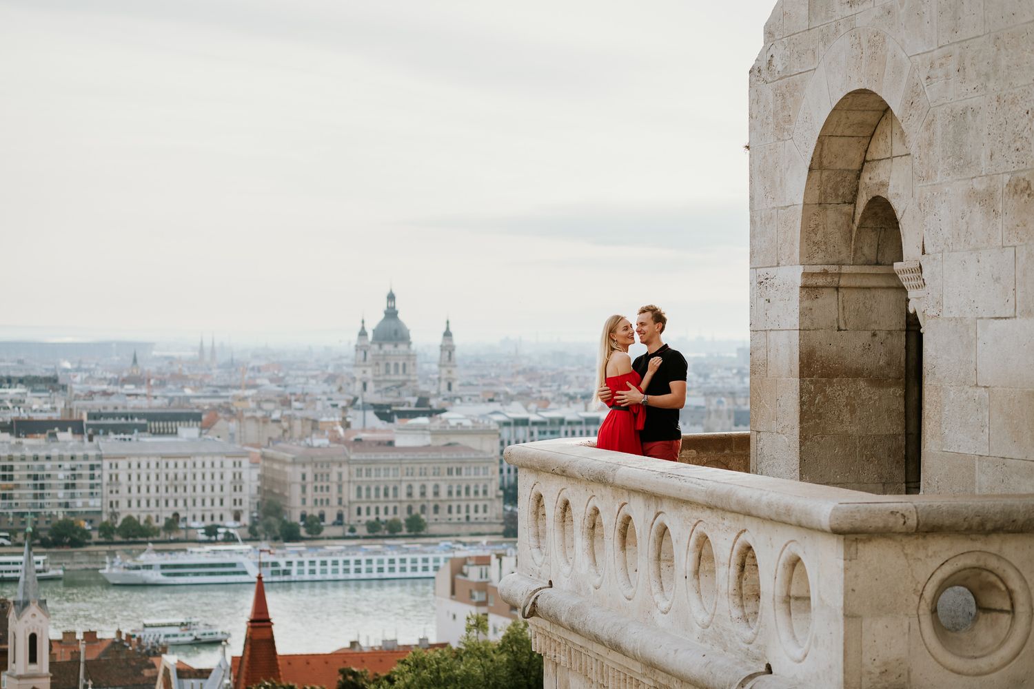 Couple having fun standing on the balcony of Fisherman's Bastion in Budapest during a professional photo shoot with a local photographer