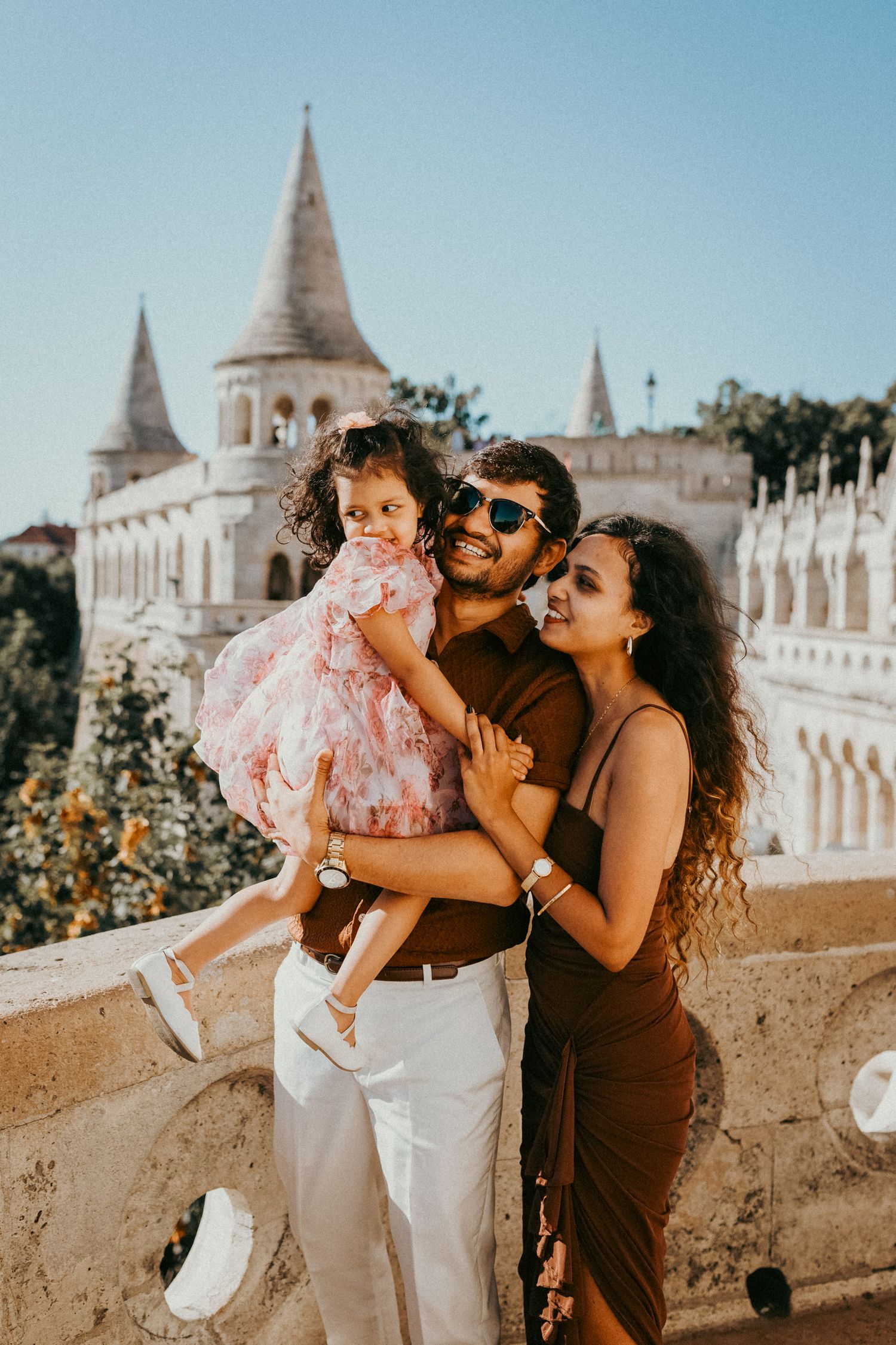 Mom, dad, and thir little daughter dressed elegantly for their summer photo shoot in Budapest