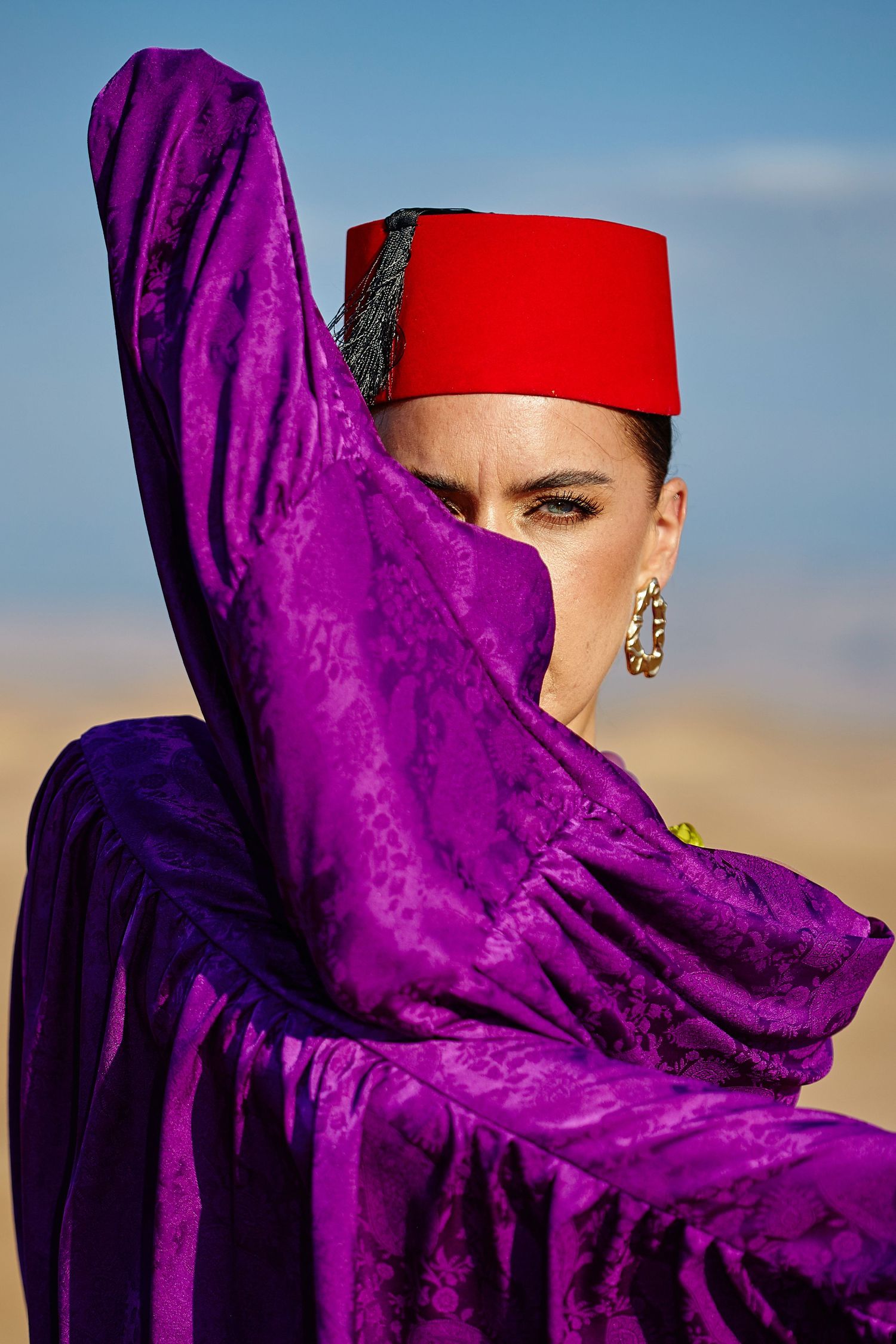 woman wearing red moroccan hat with blue eyes - Marrakech by Ahmed Bahhodh