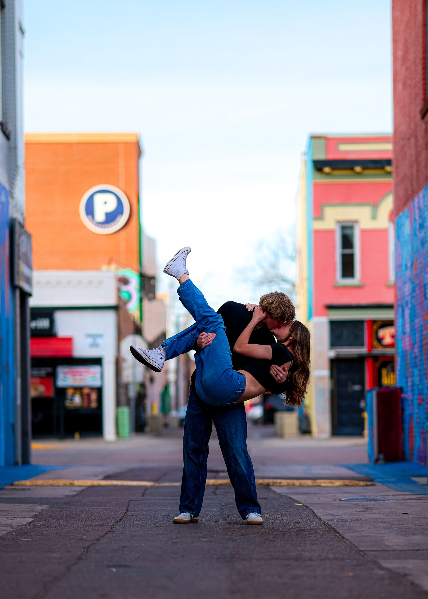 Couple in an alley with hime holding/dipping her downward as they kiss