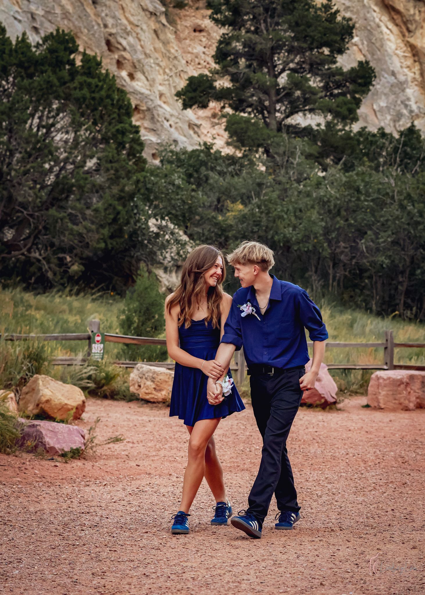 Couple walking on a gravel path looking at each other