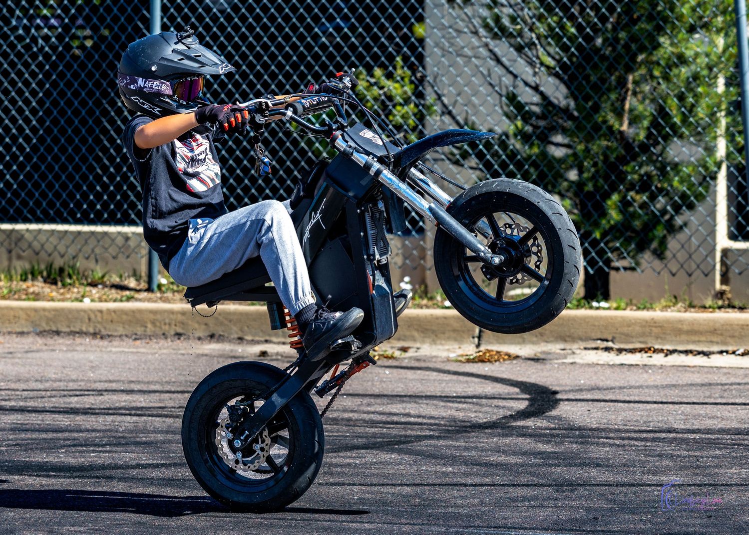Sound child on a small motorcycle up on one wheel