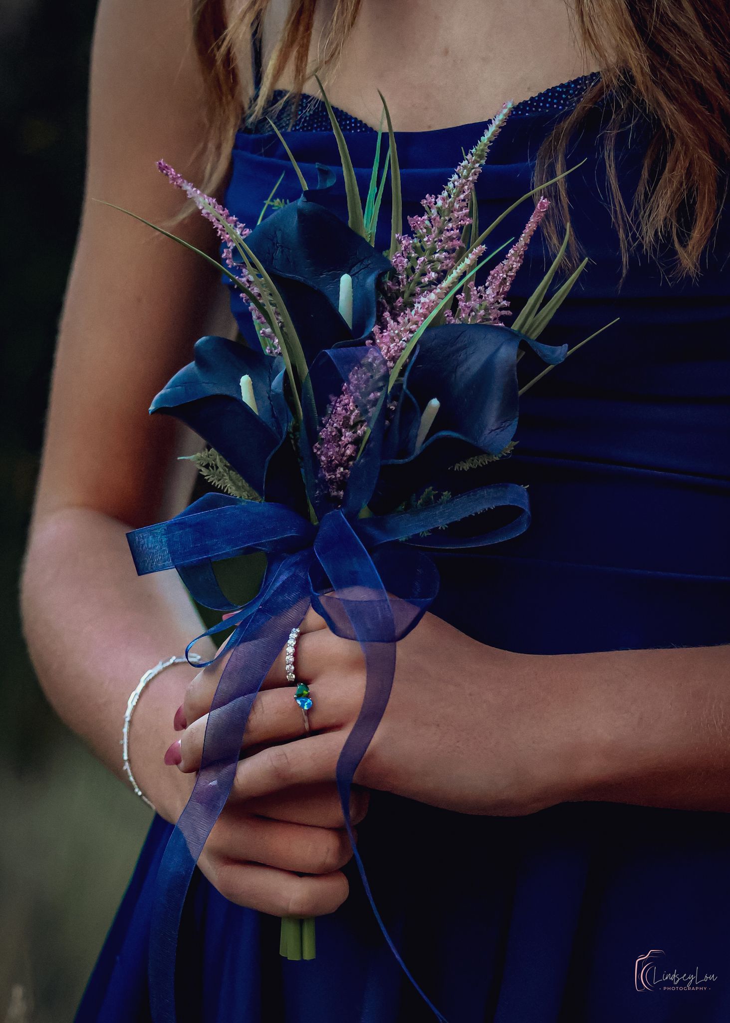 Young lady's floral arrangement in front of her as she hold is