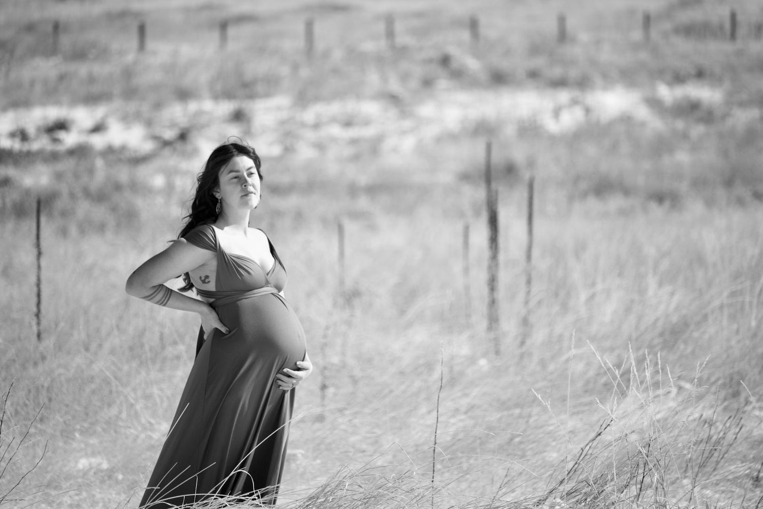 Pregnant woman posing in a field with snow