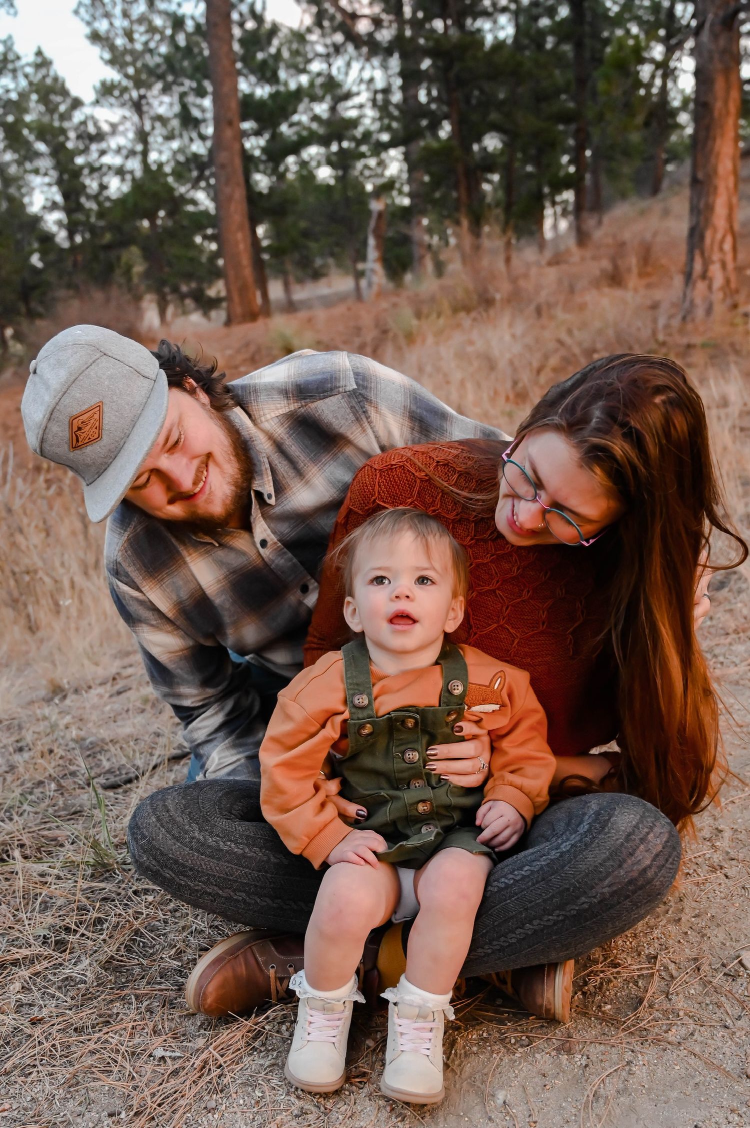 A family posing for a photo together in the forest