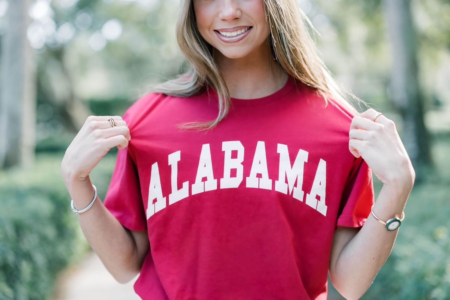 Woman wearing red Alabama university t-shirt in outdoor photoshoot.