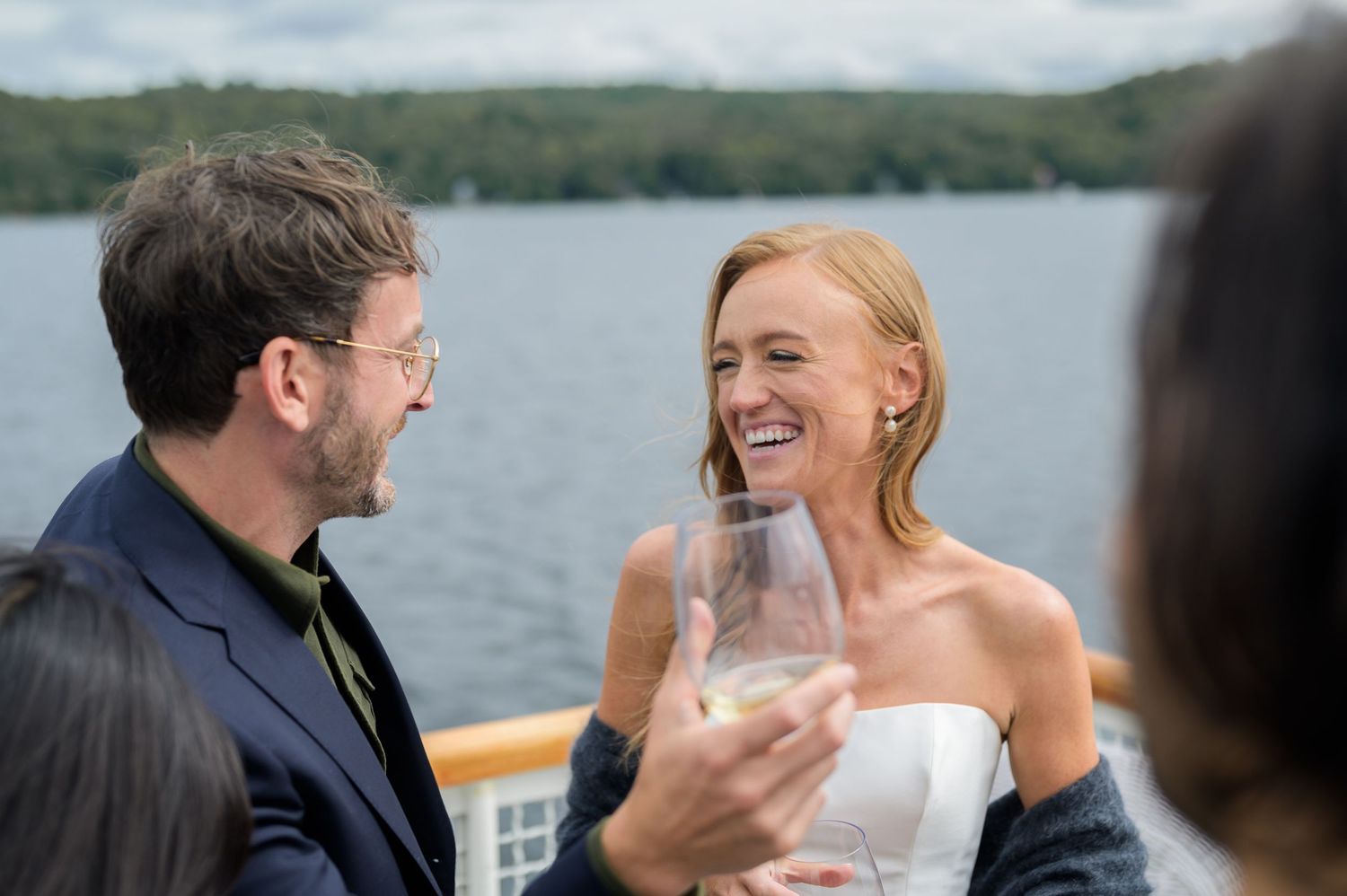 A happy couple shares a tender moment while enjoying a boat ride on a scenic lake.