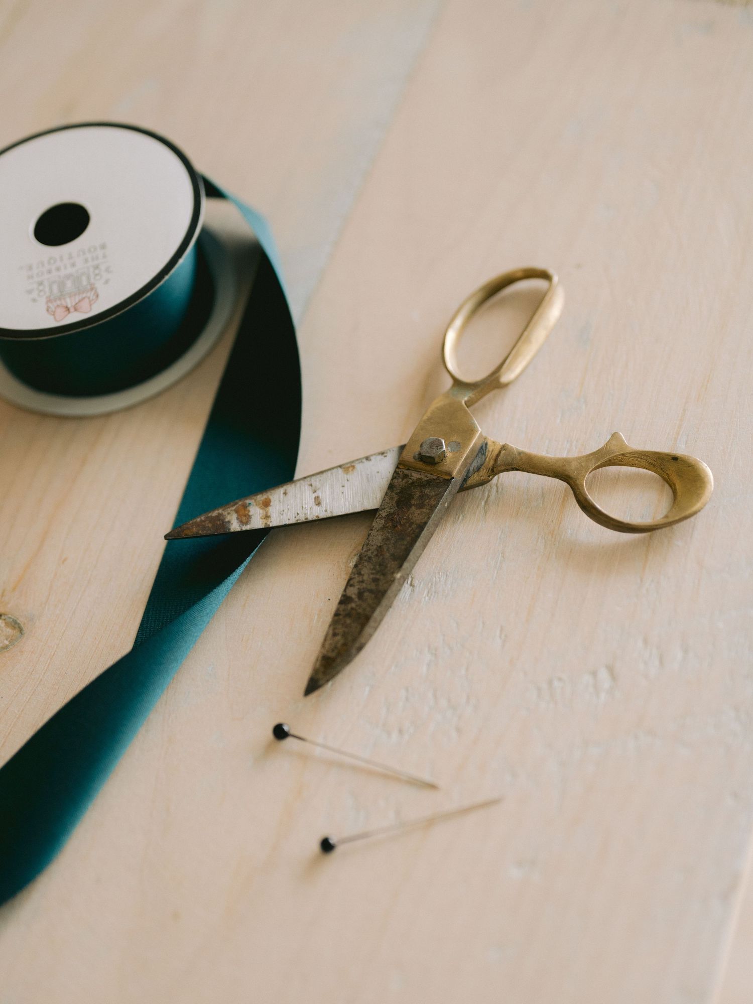 A series of minimalist images showing sewing supplies and thread spools on a light wooden surface.