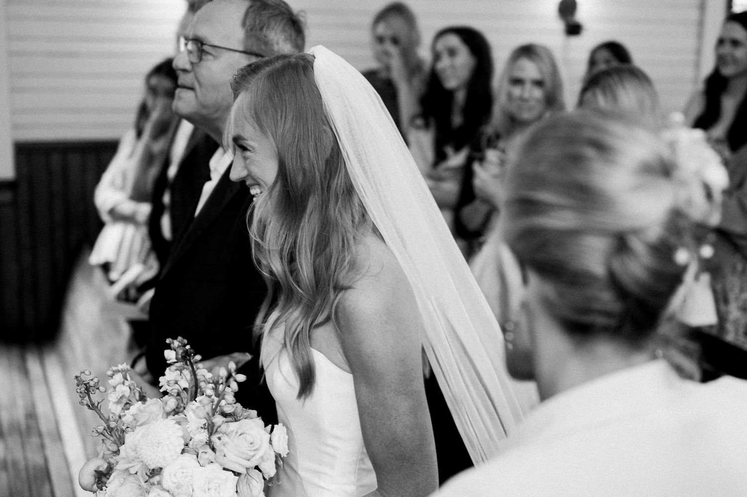Wedding guests share emotional moments and laughter during indoor celebration.