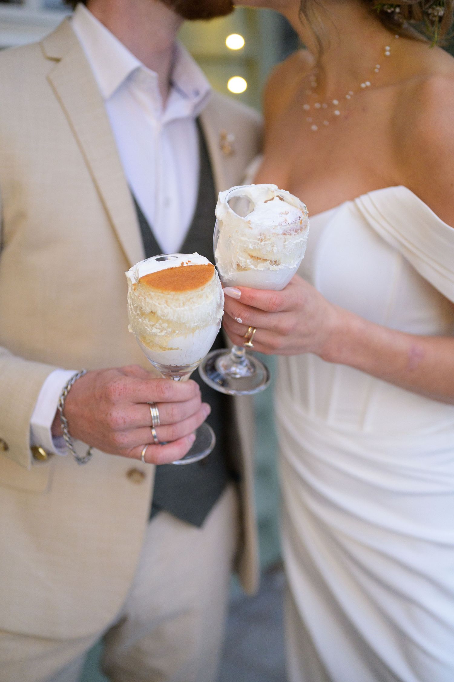 Couple toasting with decadent whipped icing topped dessert drinks at their wedding celebration.