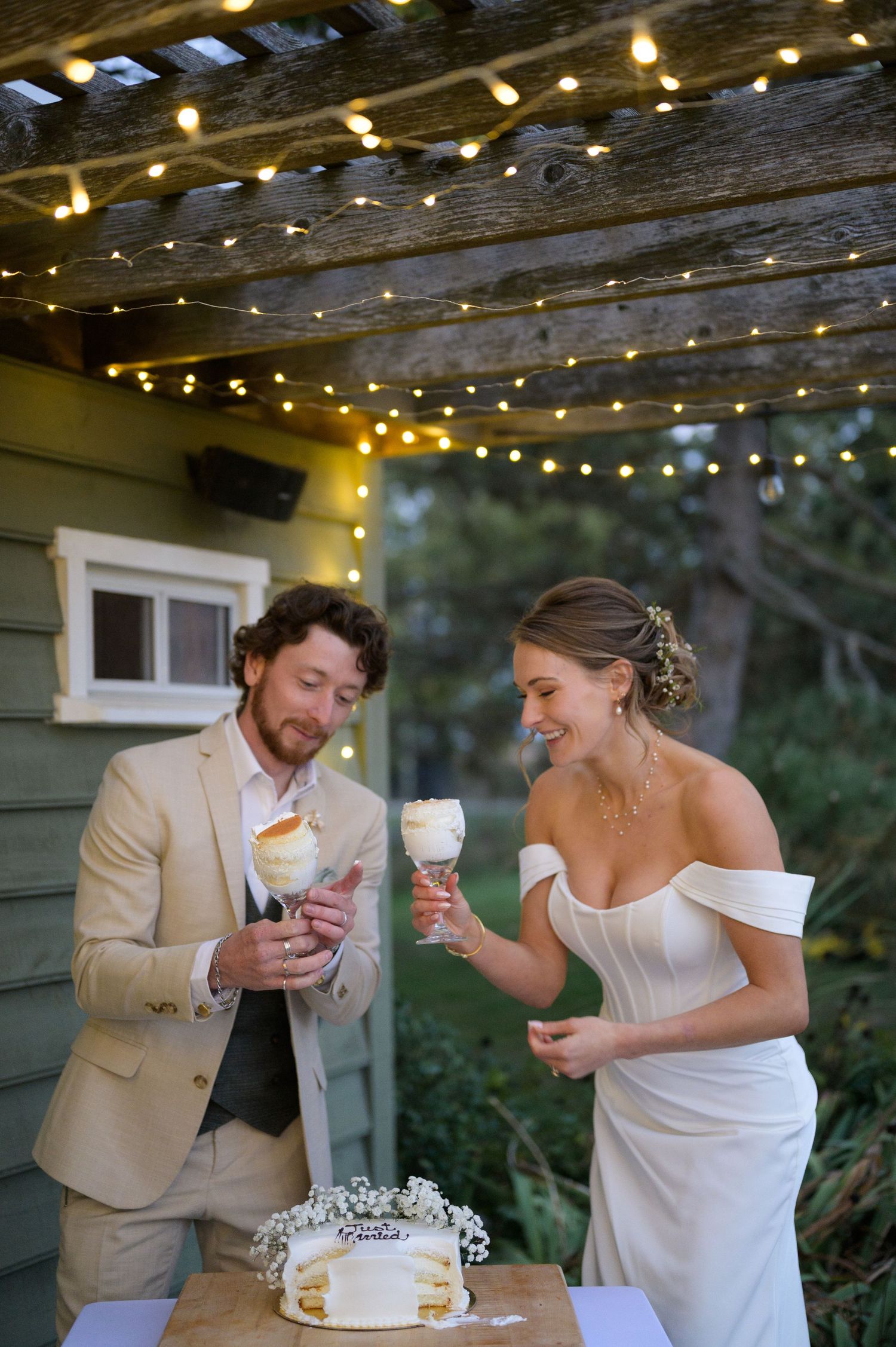 String lights illuminate a rustic wooden ceiling as a couple enjoys ice cream cones.
