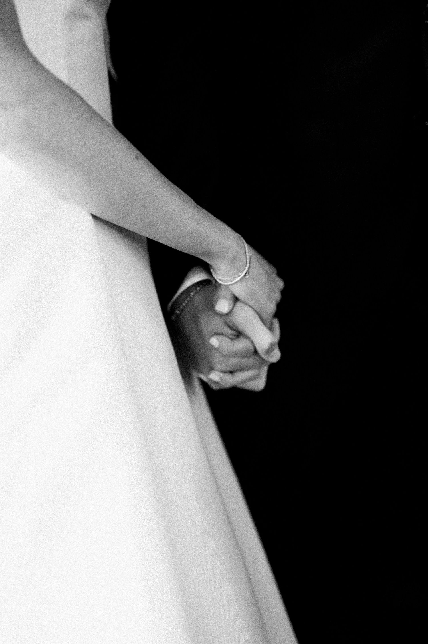 Close-up detail of a white wedding dress showing delicate fabric and elegant design elements.