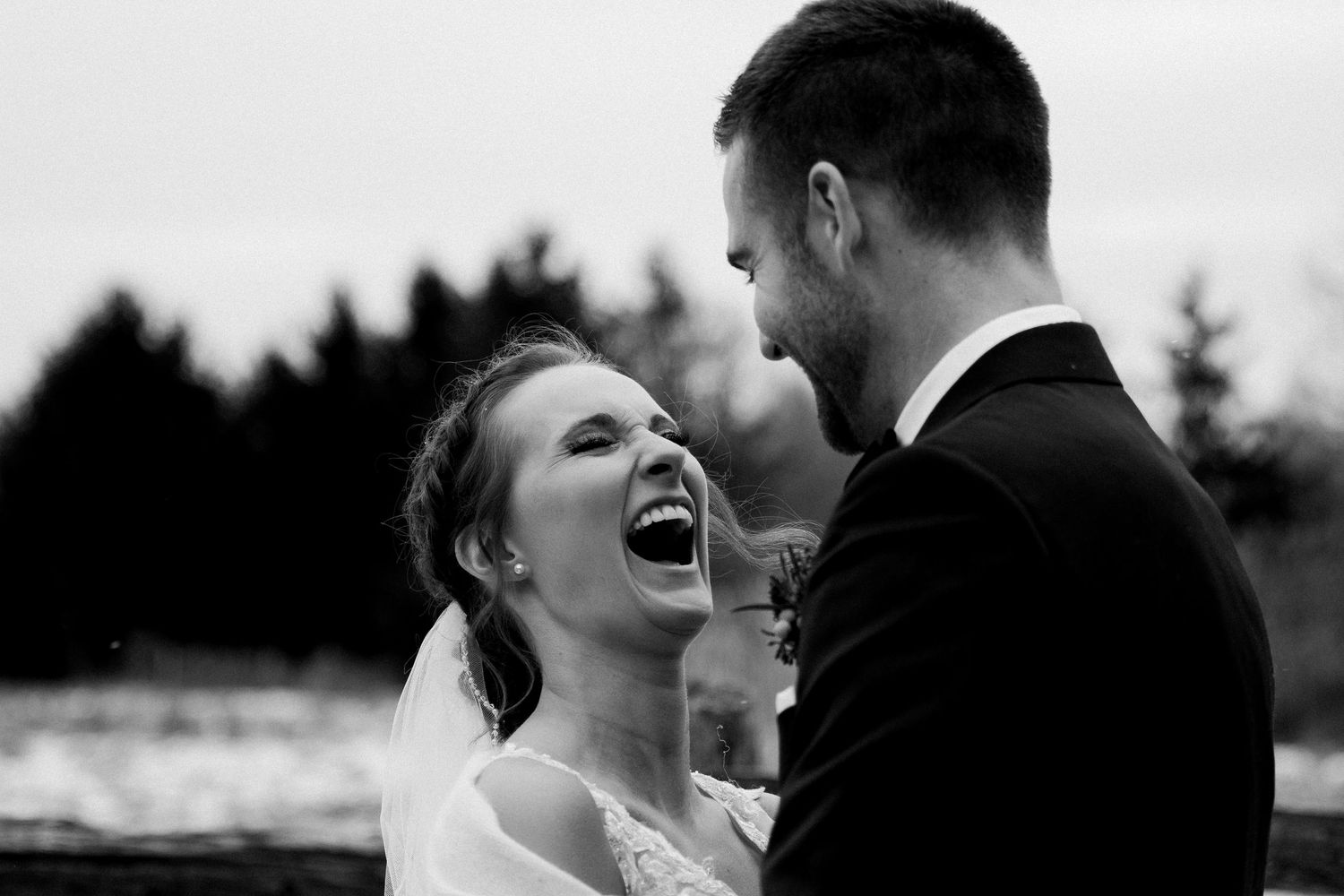 A joyful couple shares an intimate moment together during their outdoor wedding photoshoot.
