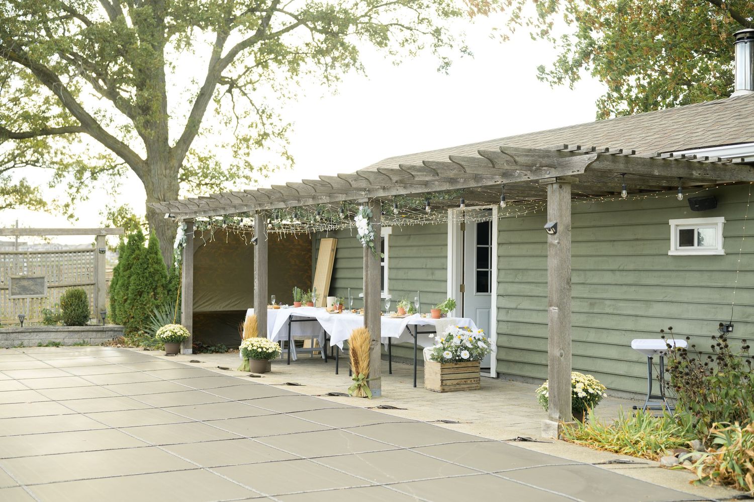 A panoramic view of gray ranch-style buildings with trees in a row along the exterior.