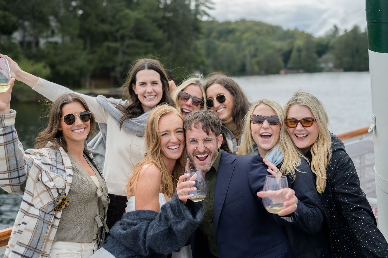Group of friends having fun and posing together outdoors in casual clothing and sunglasses.