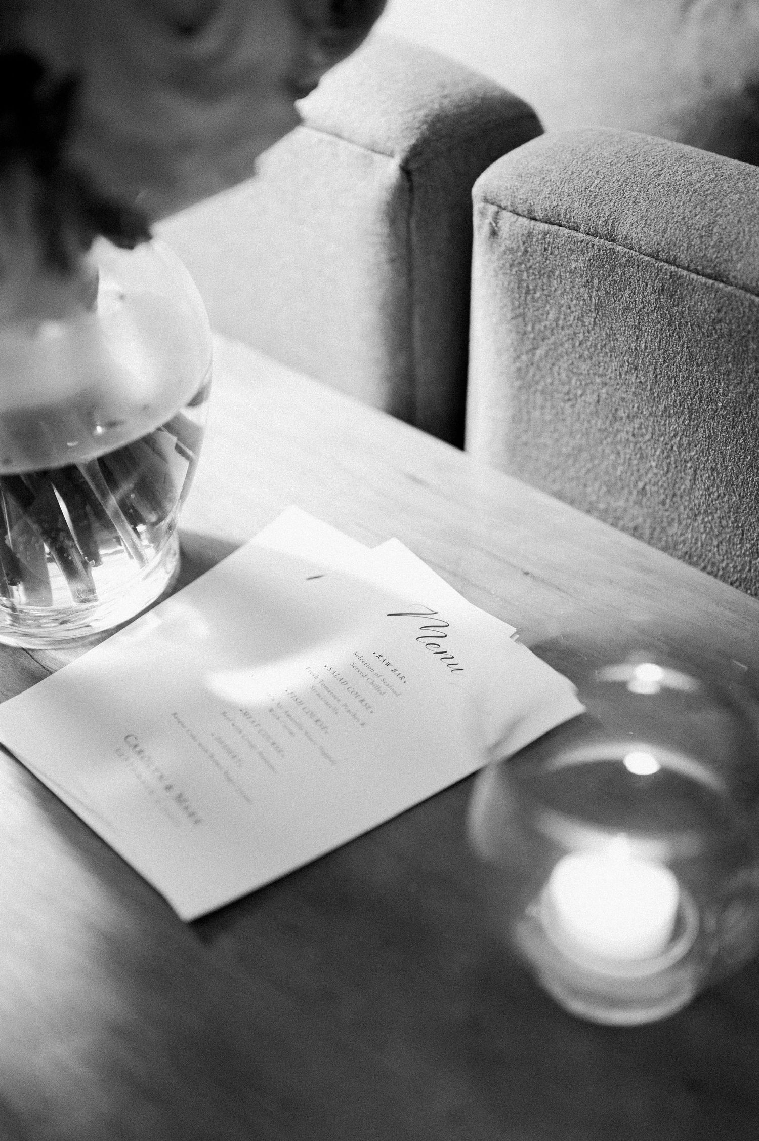 A series of black and white photos showing hands writing on paper with candlelight illumination creating a romantic ambiance.