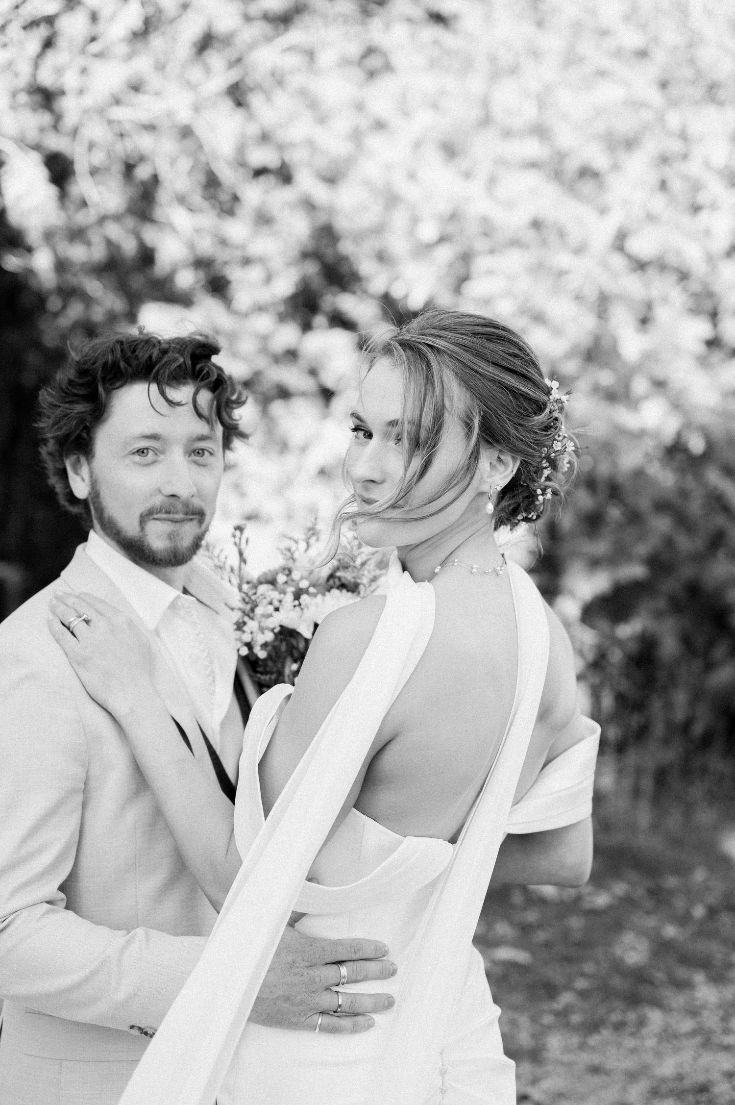 A romantic black and white photo series of a couple sharing tender moments in a garden setting.