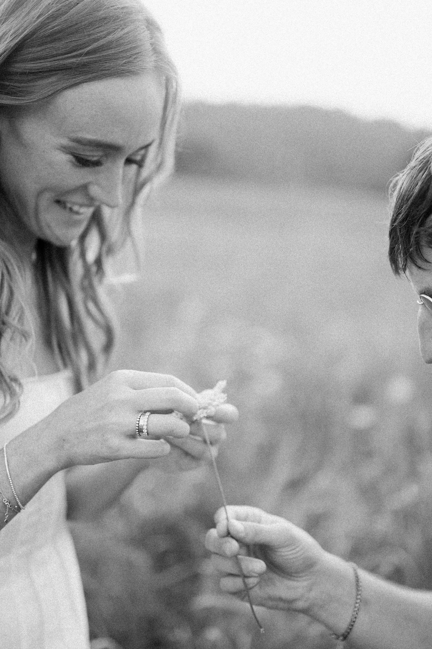 A series of black and white photos showing someone examining a ring outdoors in natural lighting.