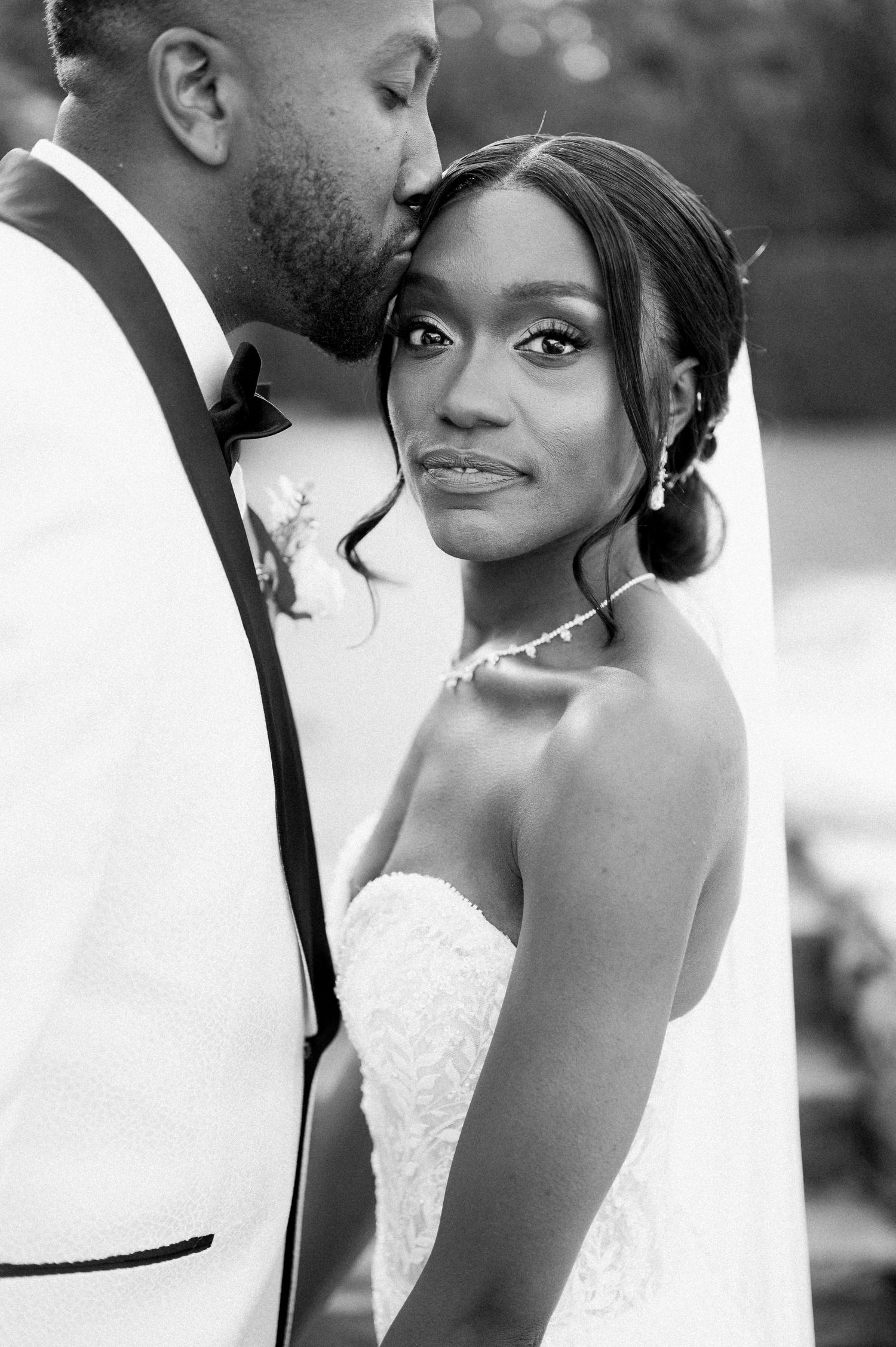 Black and white wedding photos show intimate moments between newlyweds in elegant attire with romantic expressions.