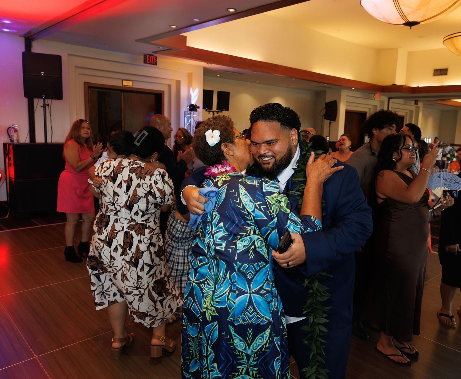 Guests dancing and celebrating at lively wedding reception in elegant banquet hall venue.