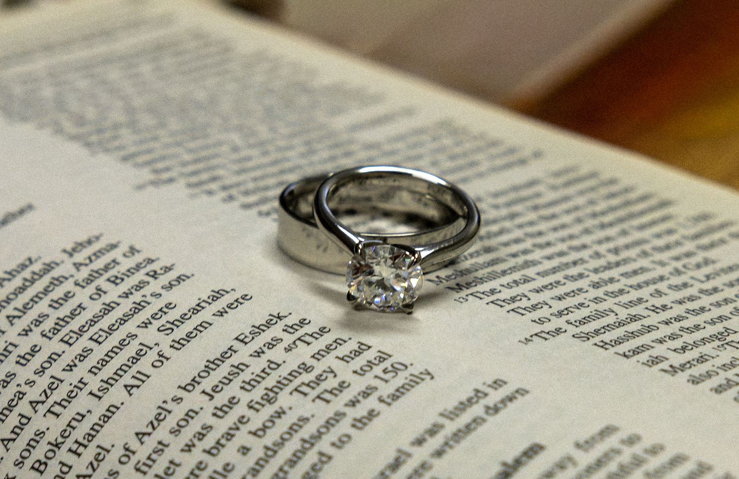 A diamond solitaire engagement ring resting on an open Bible, symbolizing faith and commitment.