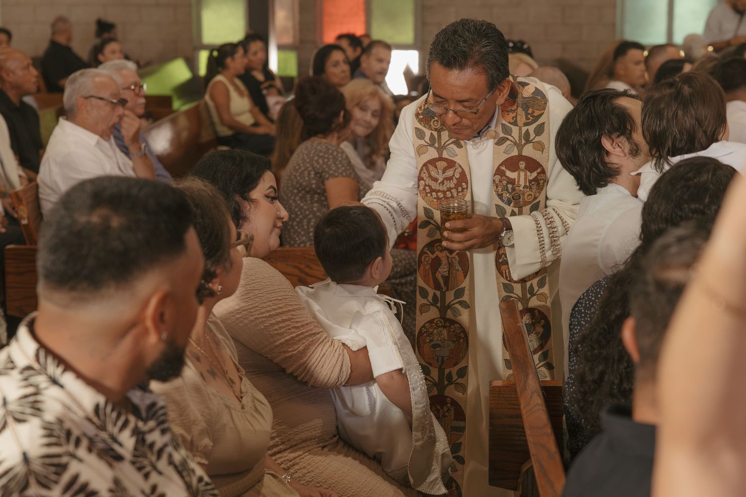 Priest distributing communion to congregation during a Catholic church service.