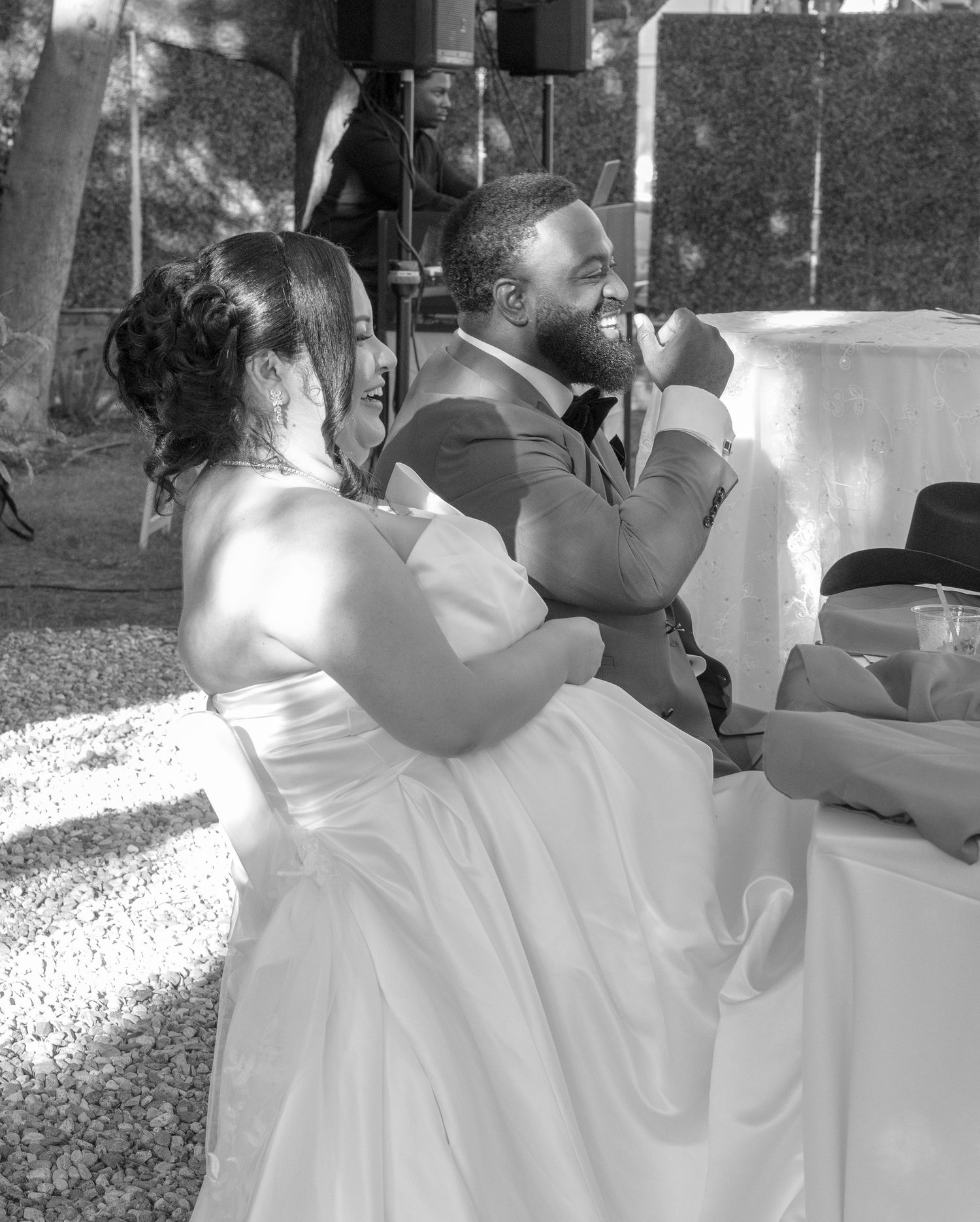 Bride and groom share a tender moment together at their outdoor wedding reception table.
