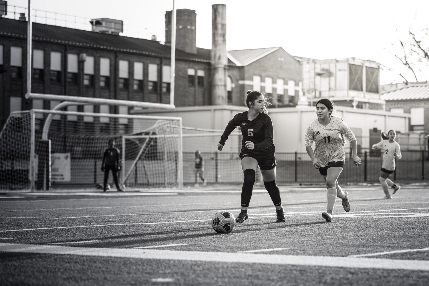 R.L. Paschal High School Varsity Girls Soccer Player kicks the ball around to avoid the defense.