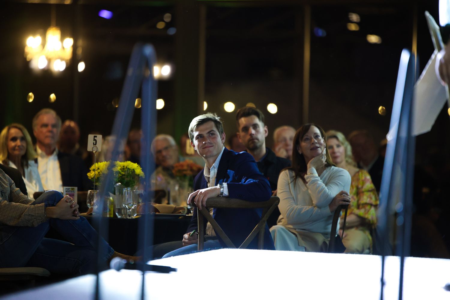 A guest at the Fort Worth YoungLife Banquet watches the inspiring video projected at the venue to show how YoungLife works in the community.