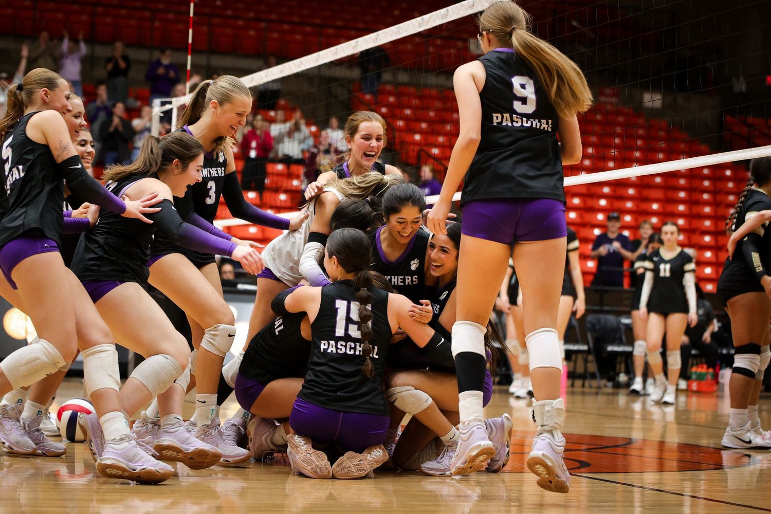 R.L. Paschal High School team celebrates on the court after becoming Bi-District Champions. The Varsity Volleyball team in Fort Worth, Texas