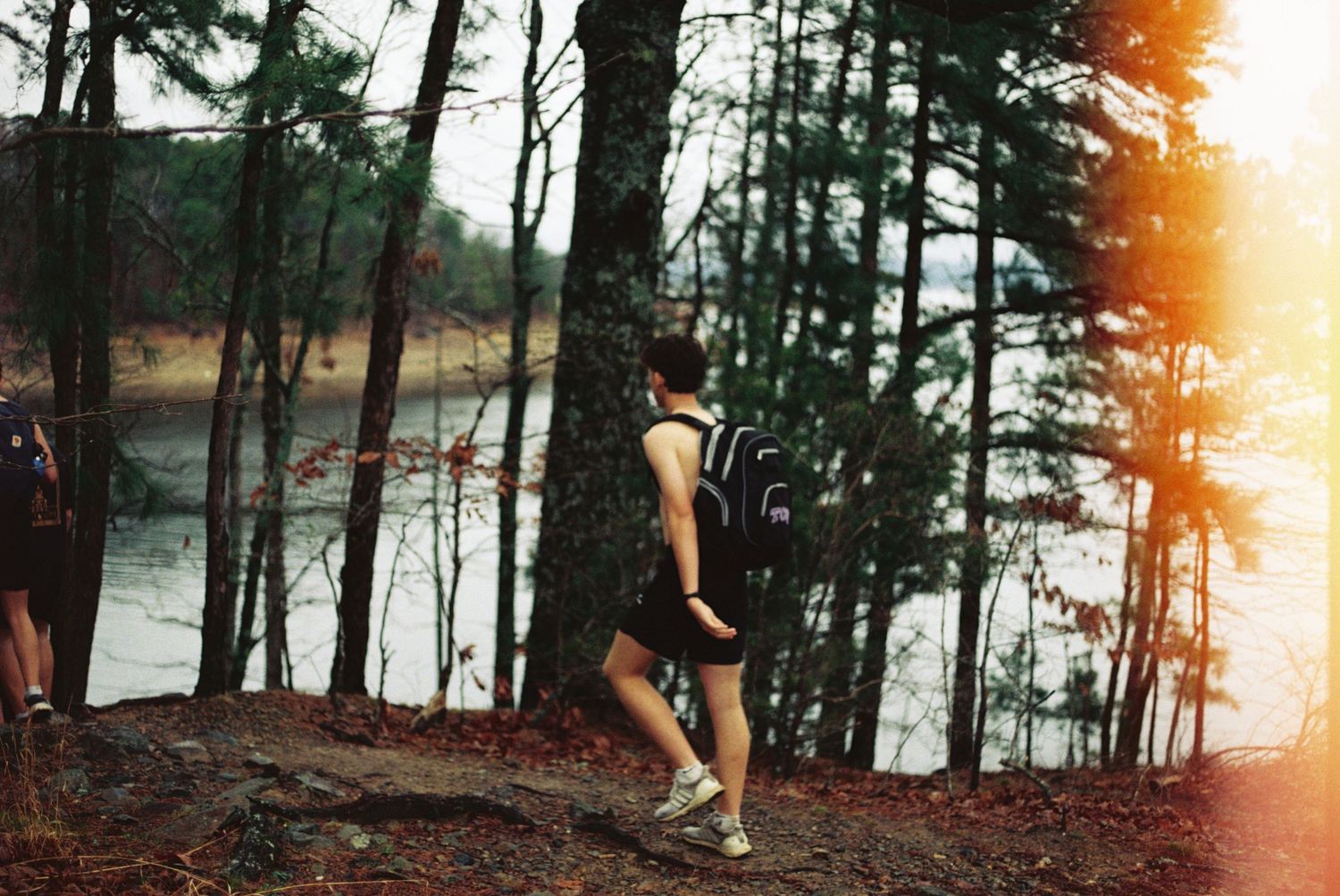 R.L. Paschal High School YoungLife group explores the woods of Broken Bow, Oklahoma, and finds a lake. This is a film photo.