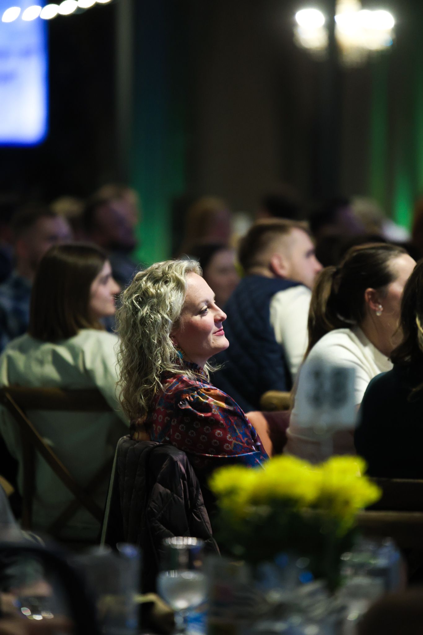 A guest at the Fort Worth YoungLife Banquet watches the inspiring video projected at the venue to show how YoungLife works in the community.