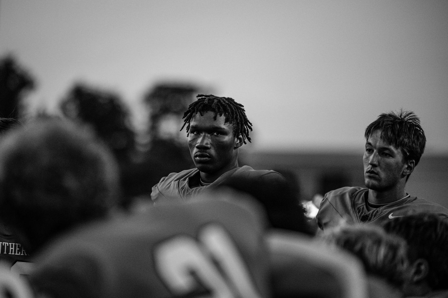 R.L. Paschal High School Varsity Football Player kneels and listens to the coach's words of encouragement.