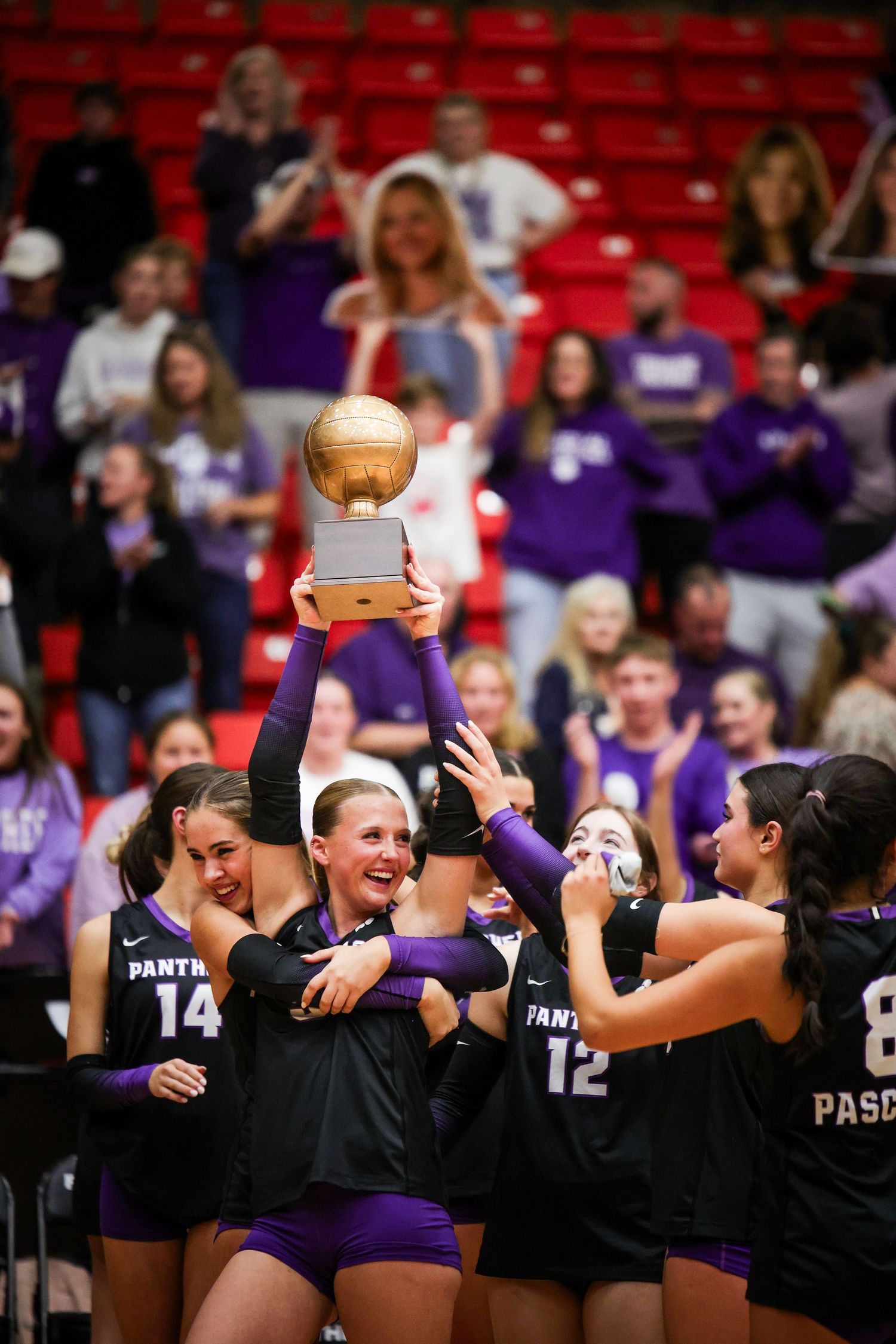 R.L. Paschal High School team celebrates on the court, becoming Bi-District Champions. The Varsity Volleyball team holds the trophy high