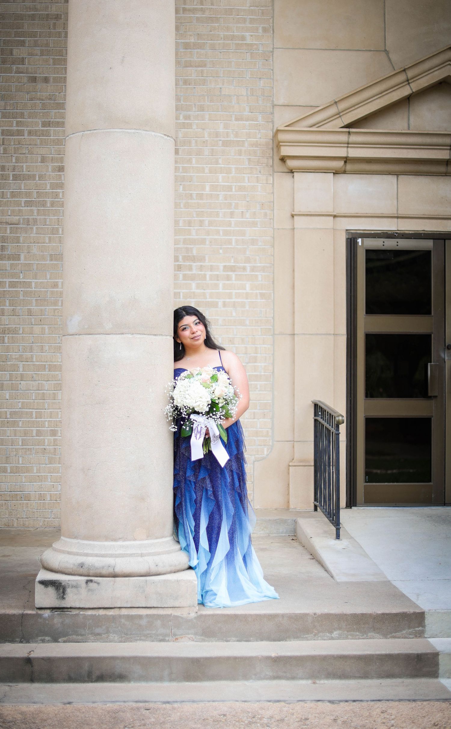 R.L. Paschal High School student poses on a historic college building during her prom photos.