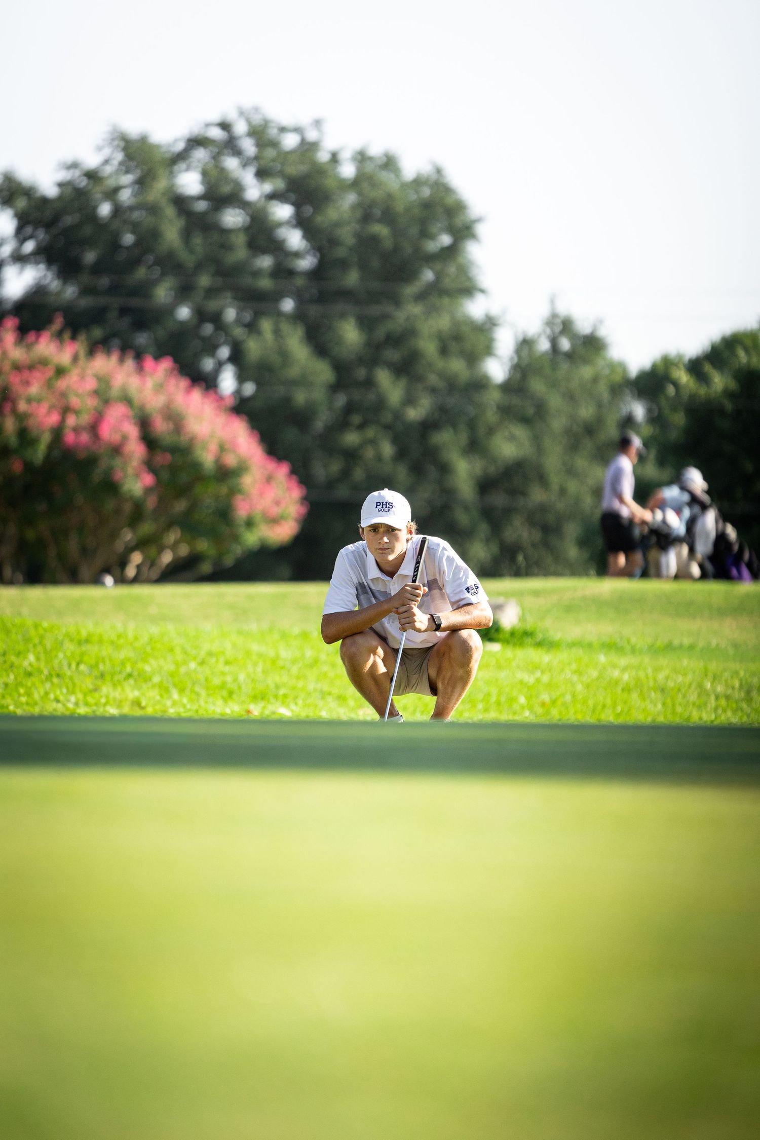 R.L. Paschal High School Varsity Golfer looks for the perfect angle to putt his ball at the annual Bart Granger Tournament at Pecan Valley.