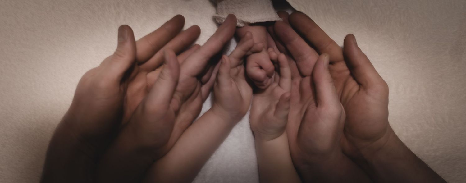 Diverse hands of different skin tones coming together in unity, symbolizing teamwork and inclusion.